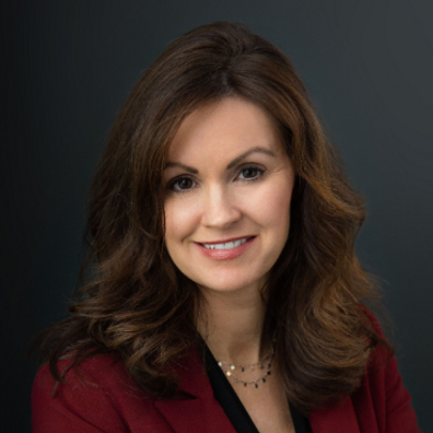 Cozakos and Centeno : Professional portrait of a woman with shoulder-length brown hair, wearing a red blazer and a necklace, smiling at the camera.